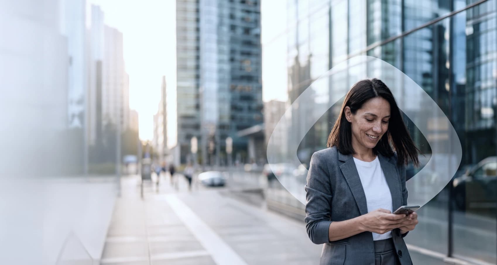 Mujer revisando su teléfono mientras camina por la ciudad